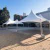 Two 20' x 30' white high-peak marquee tents set up on a paved courtyard at UBC in Vancouver, ready for an outdoor pop-up clothing sale.