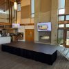 8x16 black portable stage with black skirting and aluminum stairs set up in the lounge at Riverway Clubhouse in Burnaby, BC