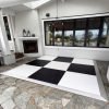12' x 12' black and white checkerboard dance floor on a stone patio in front of a modern white house with fireplace and large windows, low-profile ramp edging for smooth step-on